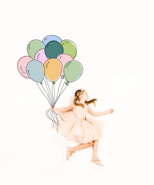 Vue du dessus de mignon enfant en robe rose tenant des ballons colorés sur blanc — Photo de stock