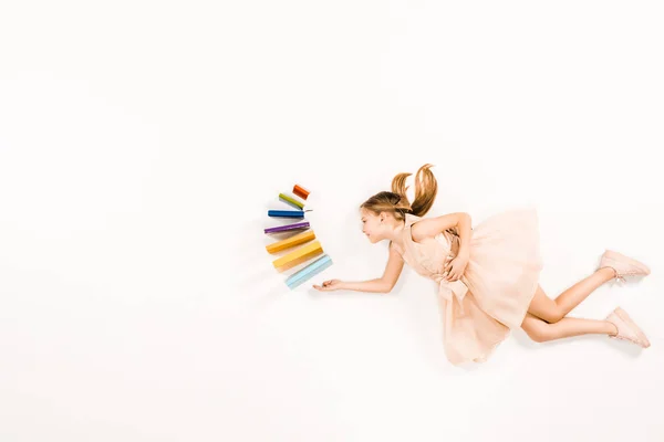 Blick von oben auf ein fröhliches Kind im rosa Kleid, das Bücher in der Hand hält und auf Weiß fliegt — Stockfoto