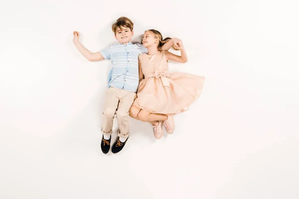 Вид зверху весела дитина в рожевій сукні тримає руки з другом на білому — стокове фото