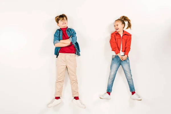 Vue de dessus du gamin joyeux proche ami avec les bras croisés sur blanc — Photo de stock