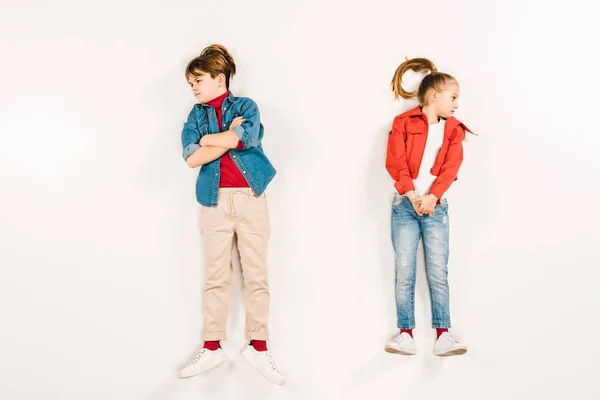 Top view of displeased kid with crossed arms near friend on white — Stock Photo