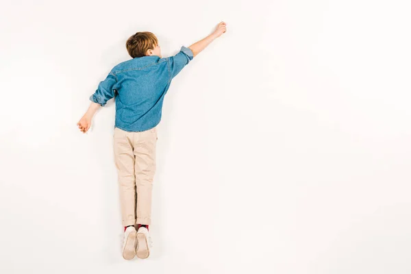 Top view of kid lying and gesturing on white — Stock Photo