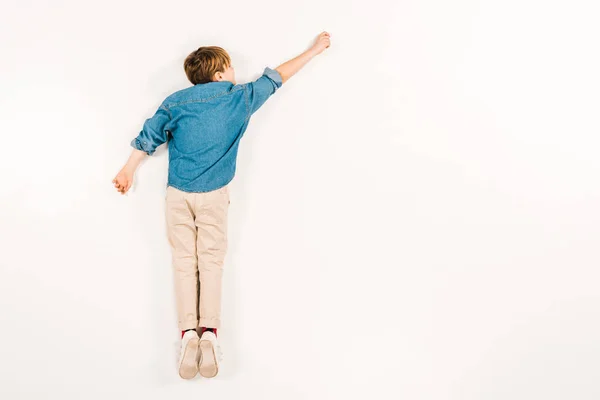 Vue de dessus de l'enfant couché et gesticulant sur blanc — Photo de stock