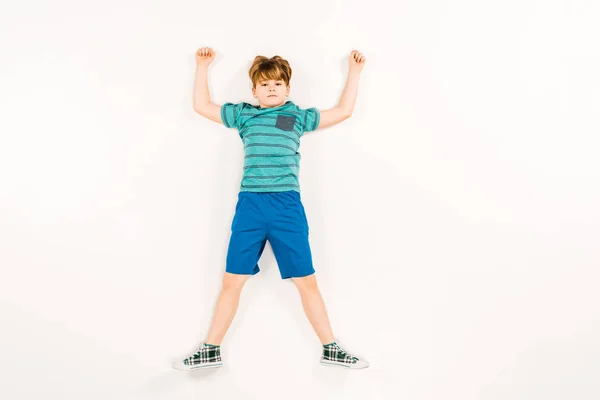 Top view of cute kid with hands above head looking at camera on white — Stock Photo