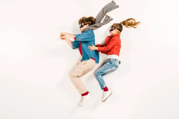 Vista dall'alto di bambini felici in maschere super eroe gesticolando sul bianco — Foto stock