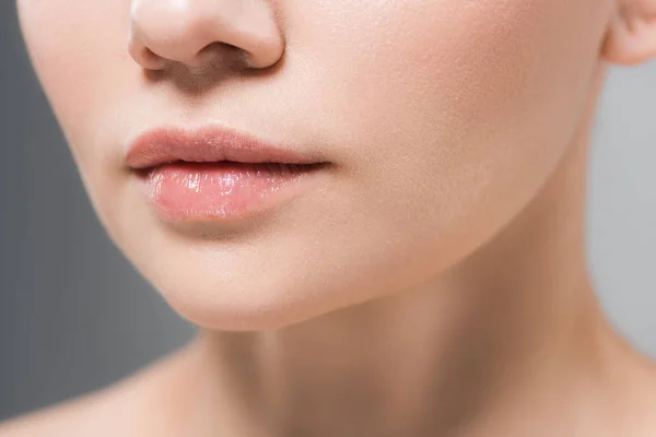 Vista ritagliata di giovane donna con labbra morbide isolate sul grigio — Foto stock