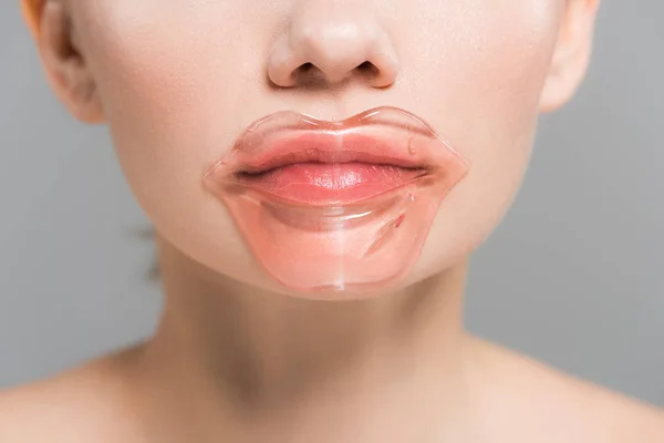 Ausgeschnittene Ansicht einer jungen Frau mit Lippenmaske isoliert auf grau — Stockfoto