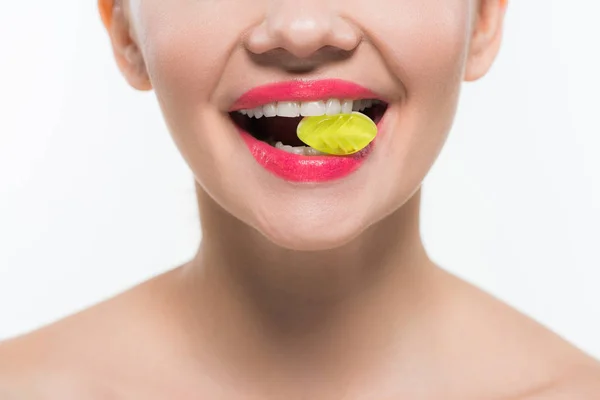 Cropped view of nude cheerful girl eating yellow jelly candy isolated on white — Stock Photo