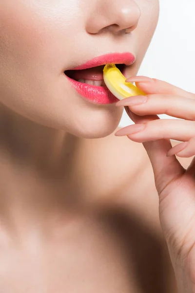 Vista recortada de niña comiendo caramelo de jalea amarilla aislado en blanco - foto de stock