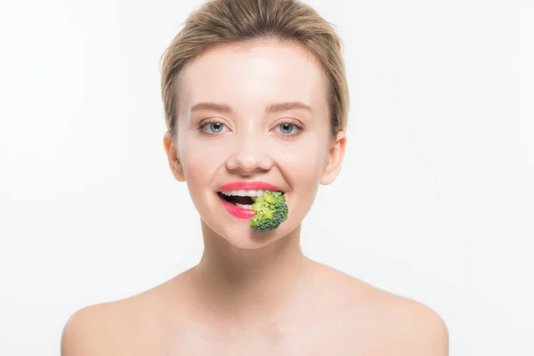 Atractiva mujer desnuda comiendo brócoli maduro verde aislado en blanco - foto de stock