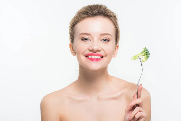 Cheerful naked woman holding fork with green ripe broccoli isolated on white — Stock Photo