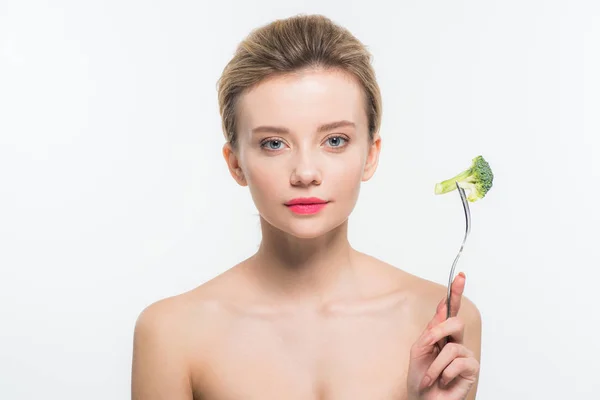 Atractiva mujer desnuda sosteniendo tenedor con brócoli maduro verde aislado en blanco - foto de stock