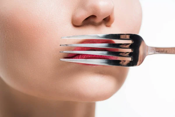 Vista recortada de la mujer sosteniendo tenedor de plata cerca de los labios aislados en blanco - foto de stock