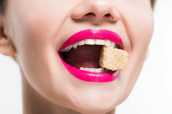 Vista cortada de mulher feliz comendo cubo de açúcar isolado no branco — Fotografia de Stock