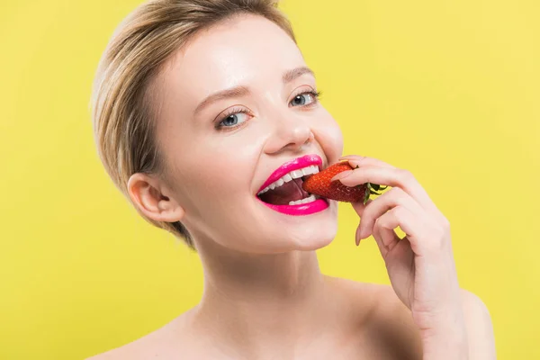 Приваблива жінка з рожевими губами їсть полуницю ізольовано на жовтому — Stock Photo