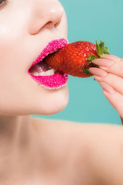Vue recadrée de la femme avec du sucre sur les lèvres manger savoureuse fraise isolé sur bleu — Photo de stock