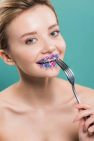 Femme nue gaie tenant fourchette argentée près de saupoudrer sur les lèvres isolées sur bleu — Photo de stock
