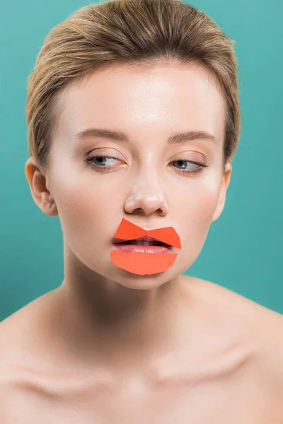 Attractive nude woman with orange paper on lips isolated on blue — Stock Photo