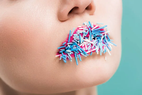 Vista recortada de la mujer joven con aspersiones en los labios aislados en azul - foto de stock