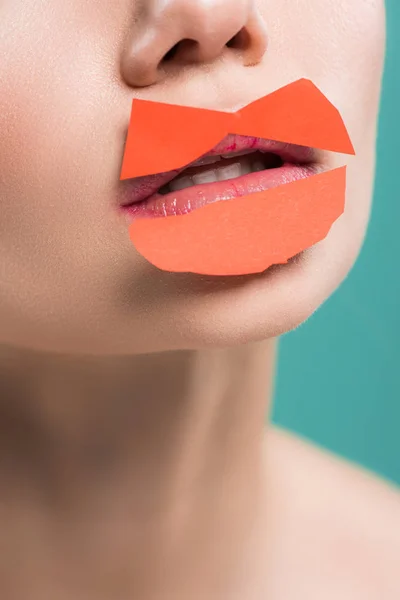 Vista ritagliata di giovane donna con carta arancione su labbra isolate su blu — Foto stock