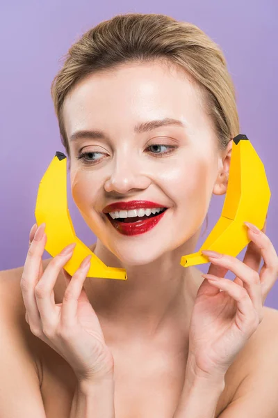 Heureuse jeune femme nue tenant des bananes décoratives isolées sur violet — Photo de stock