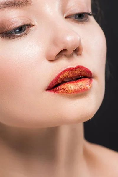 Close up of attractive woman with orange lips isolated on black — Stock Photo