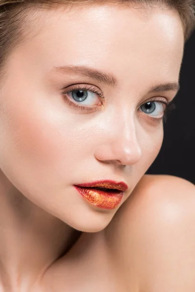 Close up of beautiful young woman with orange lips isolated on black — Stock Photo