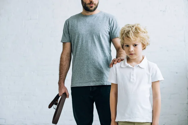 Vista ritagliata del padre con cintura e figlio sconvolto a casa — Foto stock