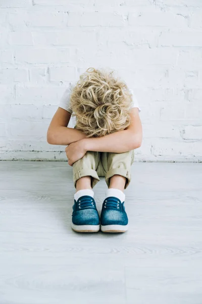 Расстроен мальчик сидит на полу дома — стоковое фото