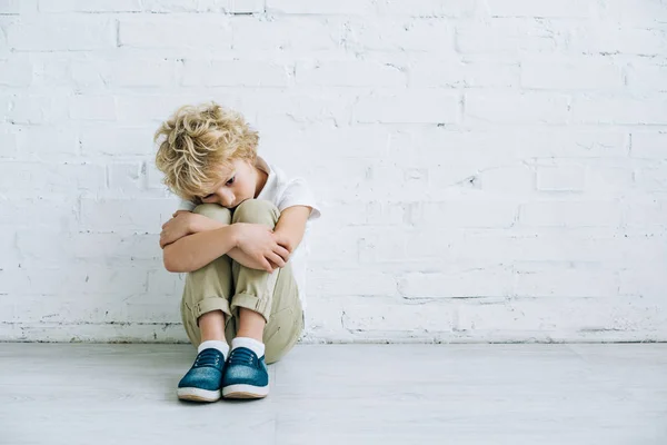 Sconvolto preteen ragazzo seduto sul pavimento a casa — Foto stock