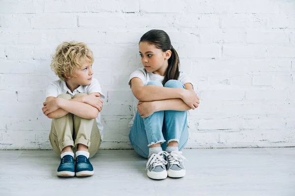 Засмучена сестра і брат сидять на підлозі вдома — стокове фото