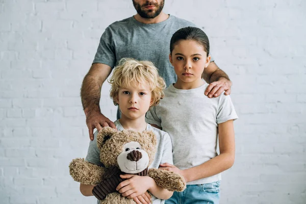 Частковий вид на батька і дітей з плюшевим ведмедем вдома — стокове фото