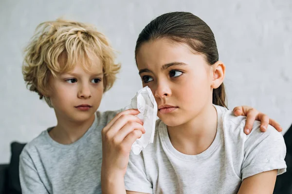 Little brother consoling crying sister in living room — Stock Photo
