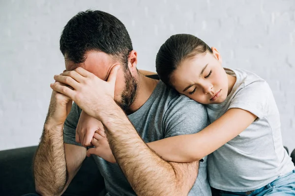 Menino triste abraçando pai estressado na sala de estar — Fotografia de Stock