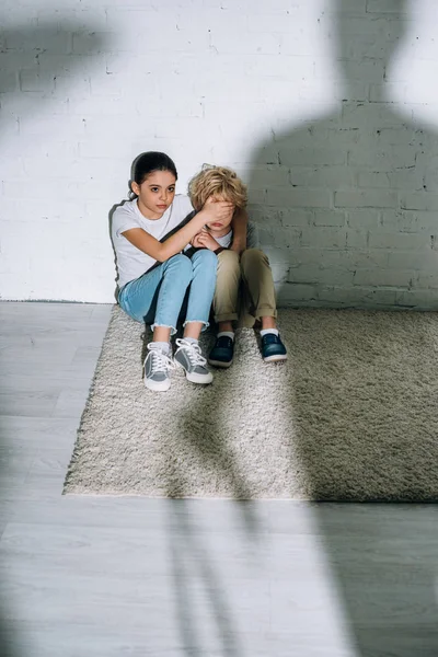 Big silhouette and scared children sitting on carpet — Stock Photo