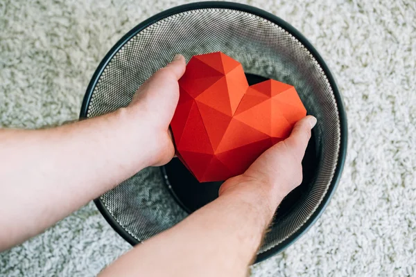 Partial view of man throwing out heart in trash can — Stock Photo