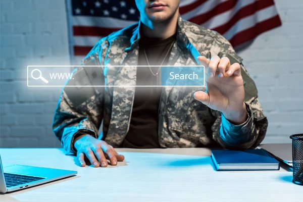 Cropped view of military man in uniform gesturing near search lettering in address bar — Stock Photo