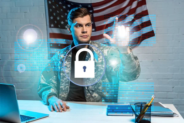 Handsome soldier in uniform pointing with finger at padlock in office — Stock Photo