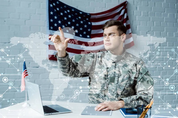 Красивий чоловік у військовій формі жестикулює біля візуалізації даних — стокове фото