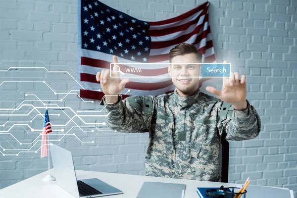 Веселий чоловік у військовій формі вказуючи пальцями в адресному рядку в офісі — стокове фото