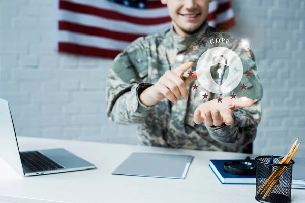 Vista recortada de hombre feliz en uniforme militar apuntando con el dedo a la nube con candado - foto de stock