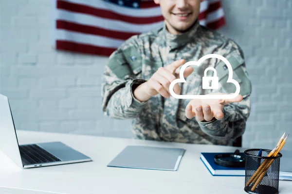 Ausgeschnittene Ansicht eines fröhlichen Mannes in Militäruniform, der mit dem Finger auf Wolke mit Vorhängeschloss zeigt — Stockfoto