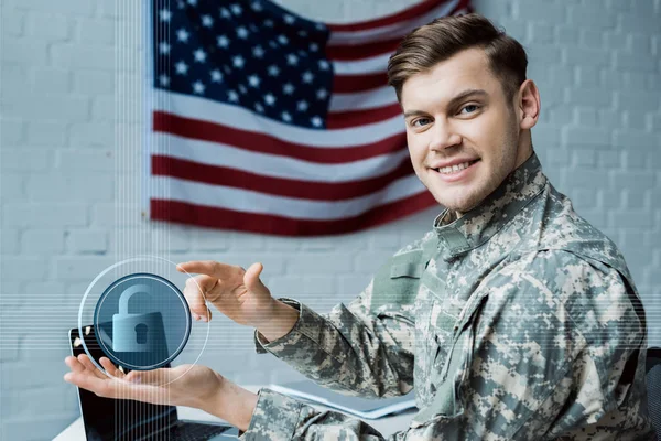 Happy military man gesturing in office near virtual padlock and laptop — Stock Photo