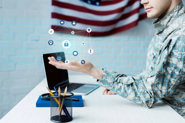 Vista recortada de soldado haciendo gestos cerca de la computadora portátil con pantalla en blanco y visualización de datos — Stock Photo