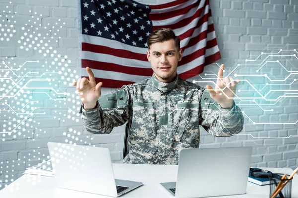 Hombre alegre en uniforme militar señalando con los dedos a la visualización de datos — Stock Photo