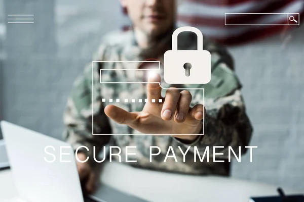 Selective focus of man in camouflage uniform pointing with finger at virtual padlock with secure payment lettering — Stock Photo