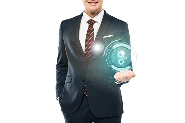 Cropped view of cheerful man in suit smiling and gesturing near cogwheel icon on white — Stock Photo