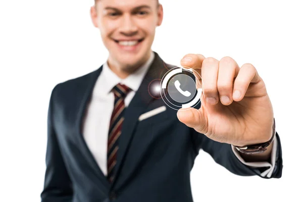 Selective focus of happy businessman gesturing and smiling while touching virtual phone icon isolated on while — Stock Photo