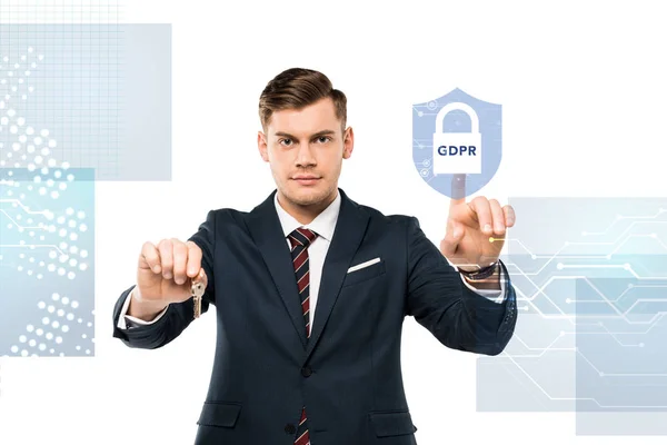 Красивый мужчина в костюме, держащий ключи и указывающий пальцем на виртуальный замок с GDPR на белом — стоковое фото