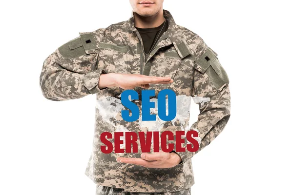 Cropped view man in military uniform gesturing near seo services lettering isolated on white — Stock Photo